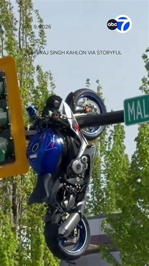 Motorcycle hangs from traffic light after crash