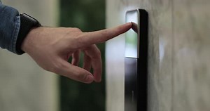 Closeup of Man Hand Presses the Elevator Call Button Elevator Door Control Concept
