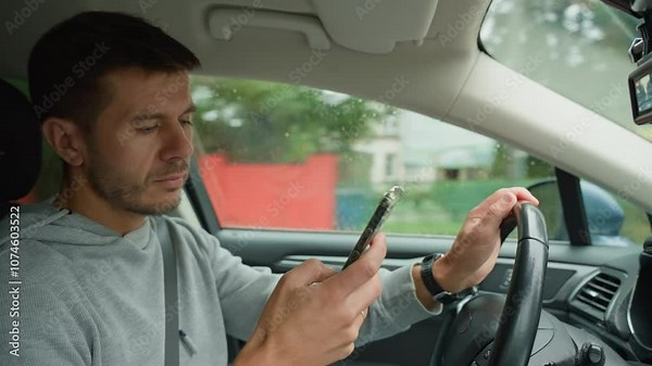 Driver using smartphone while driving car, distracted by messages on his phone. Dangerous driving of a vehicle, violation of traffic rules