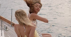 Beautiful girl friends on sailboat in ocean on luxury lifestyle happy adventure travel vacation