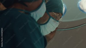 Young Asian assistants and nurses performing invasive surgery on patient in hospital operating room. Diverse team of professional surgeon, Healthcare and medical concept.
