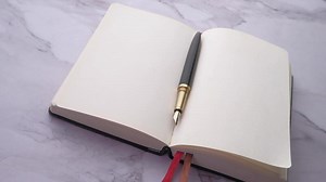 Download An open notebook with a pen on top for free