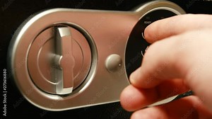 Close-up shot of a black safe being opened by a hand entering the correct pin and afterwards turning the latch to reveal it's content.