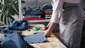 Denim Jeans Recycle and Reuse. Sustainable Fashion. Designer sew from used denim fabric, old jeans. Upcycling process brings new life to old jeans