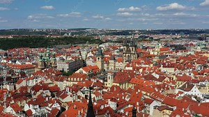 Prague beautiful panoramic sunny aerial drone view above Prague Old Town Square with Church of Our Lady before Tyn and Prague Astronomical Clock Tower. Drone flight over red roofs of Prague, Czechia.
