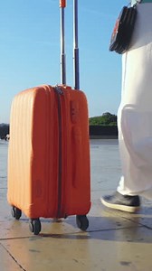 Young Woman with the Orange Suitcase on the travel. Female feet and luggage going on holiday and close up travel.