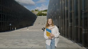 Beautiful College Student Checks On Time While Walking At The University Campus. slow motion
