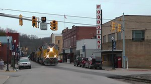 A pair of Electro-Motive Diesel Tier 4 Demonstrator locomotives lead an eastbound mixed freight train through the street-running trackage of Saint Marys, West Virginia along the former Baltimore and Ohio mainline of CSX's Ohio River Subdivision. Taken January 21, 2017. | North American Steel Veins