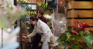 middle age asian woman shopping flowers in the florist shop Chinese florist working in the shop talking with clients picking flowers together female lifestyles