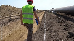 Construction Foreman Checking Progress at Gas Pipeline Construction Site