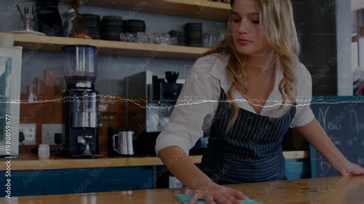 Cafe worker spotting crumbs, wiping counter with green cloth for service, dotted waveform on hands