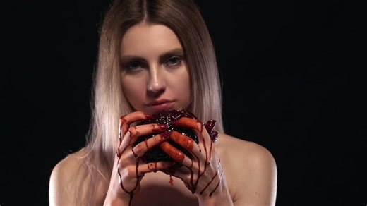 Young woman biting into a bloody heart - Free Stock Video
