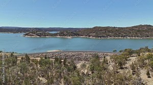 Drone footage of asphalt road adjacting Lake Oroville and recreation area in California, USA