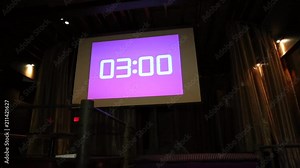 projector in action with illuminated warm pink screen and timer