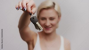 Woman dangling keys of her house, girl holding keys of her first apartment
