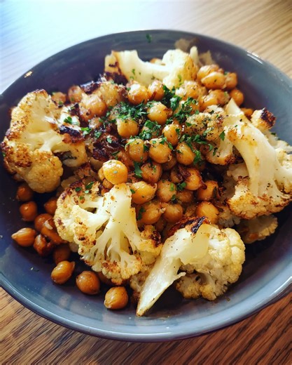Herb & Maple Roasted Cauliflower with Chickpeas Ingredients: 1 medium cauliflower, cut into florets 1 can (400 g / 14 oz) chickpeas, drained & rinsed 2 tbsp olive oil 2 tbsp maple syrup 1 tsp dried thyme 1 tsp dried rosemary Salt & pepper to taste Fresh parsley for garnish Directions: Preheat oven to 425°F (220°C). In a large bowl, toss cauliflower florets and chickpeas with olive oil, maple syrup, thyme, rosemary, salt, and pepper. Spread evenly on a baking sheet and roast for 25–30 minutes, fl