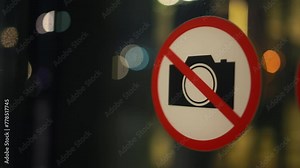 No camera sign displayed on glass window, part of building facade