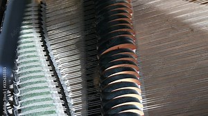 Close up of piano hammers and strings while playing on old, dusty, wooden baby grand piano. High angle, 24fps, 4k, morning light. Musical instrument, studio equipment.