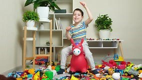 A Little Boy is Jumping on an Inflatable Rubber Donkey among the Mess in the Children S Room. Bouncing Toy for Kids. Stock Video - Video of jumper, happy: 275157639