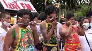 Religious devotees pierce their cheeks with skewers in Thailand
