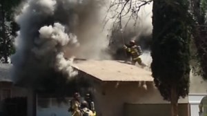 Firefighter falls through burning roof