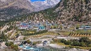 A village between mountains and a river in the Himalayas