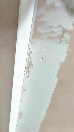 applying white smooth wall plaster using a metal trowel for finishing home renovation