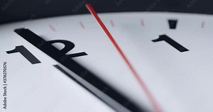 Extreme closeup shot of a wall clock with hands moving in slow motion.