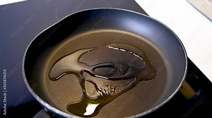 Pouring olive oil on a hot frying pan