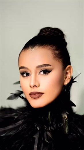 La modelo aparece de frente, con el rostro erguido y el mentón apenas elevado, proyectando una presencia imponente. En ella habita una tensión sutil pero poderosa: la fuerza no está en gestos exagerados, sino en la mirada, en la estructura misma de su rostro. Sus pómulos —definidos— y su mandíbula delineada acentúan esa sensación de integridad. Los ojos, intensos, se convierten en el punto focal: hay una mezcla de determinación y serenidad. Las pestañas, ligeramente alargadas, sombrean sutilment