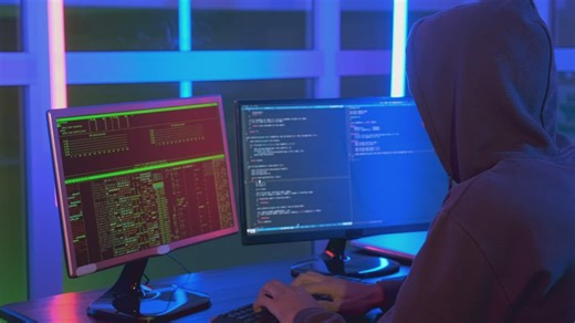 Close up of a hacker working on a computer in the dark - Free Stock Video