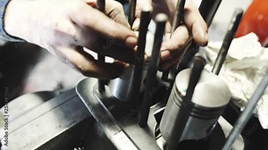 The mechanic man repairs broken engine, mechanic fixes old motorcycle engine, puts rings on pistons. Close-up shot