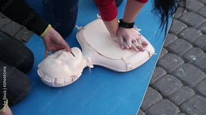 Woman volunteer instructs technique of a cardiopulmonary resuscitation, medical training