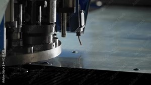 Close-up of an Automatic Stamping Machine Tool Working on a Sheet of Metal. Moving It Left and Right. Mechanical Factory Equipment. Modern Machinery. Industrial Facility Production Process.