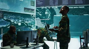 Military officers work in a high tech army control tower base, managing surveillance imagery from cctv satellite. Soldiers handle data protection to ensure national security. Camera B.
