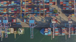 Loading and unloading a container ship in the port at the pier. Aerial view of business logistics import and export cargo transportation by container ship. Containers on a cargo vessel