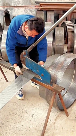 Skilled Worker Cutting Metal Mesh Sheets with Manual Guillotine