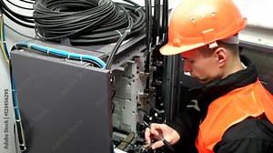 maintenance procedure on server wiring in a data centre. Close Up of network hub and cables. Male engineer of carries out an inspection server. Switch Lever On A Control Panel Of Industrial Machine