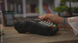 Young hands woman paying by credit card swiping with credit card on pos payment terminal on table customer machine money terminal cash client electronic slow motion