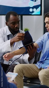 Vertical video: Physician doing insulin level measurement with medical instrument to help asian patient with diabetes during checkup visit appointment in hospital waiting room. Medicine support