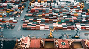 Busy container port loading and unloading cargo ship, aerial hyperlapse