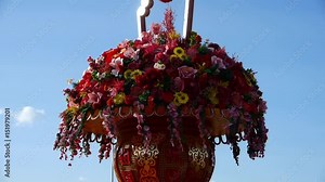gorgeous baskets full of flowers in wind.clouds in blue sky.