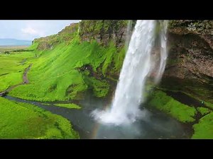 Big waterfall in rocks (10 hours) and river in green valley.