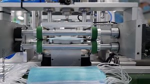 Workshop of manufacture for production of clothing, The process of manufacturing line producing medical face mask with automatic machinery in an industrial factory .