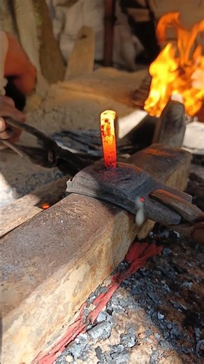 Watch how a skilled blacksmith hand-forges nails from old iron by hammering it into shape."