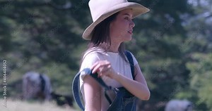 Portrait lady livestock agriculture organic cattle farmer wearing coat and cowboy hat smiling working at cow farm on the green yard surrounding with the cows