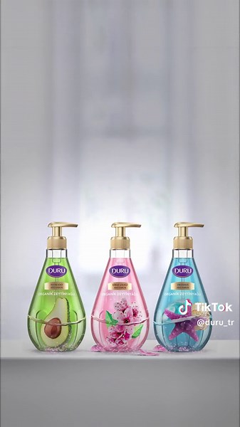 Duru Sıvı Sabun Ailesi, göz kamaştıran yeniliklerle karşınızda! 🤩 Damla şeklindeki şık şişesi ve yeni zarif gold pompası ile banyo ve mutfağınızın yıldızı olmaya hazır! 🌟 Ama asıl büyü, içinde gizli: Ellerinizi organik zeytinyağı ile yumuşacık yapan, muhteşem kokularıyla büyüleyen Duru Sıvı Sabunun İçi De Güzel Dışı Da. 💧Şimdi dene, farkı hisset! 💜 #Duru #YeniDuruSıvıSabun #OrganikZeytinyağlı