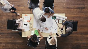 Top view of business people meeting around boardroom table discussing architectural plans for new sustainable shared office space Premium Stock Video Footage