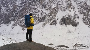 Hiker with a backpack watching the winter mountains - Free Stock Video