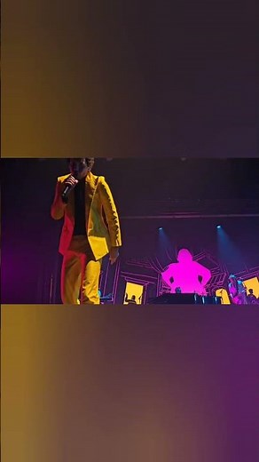 Mika gives a necklace to a fan